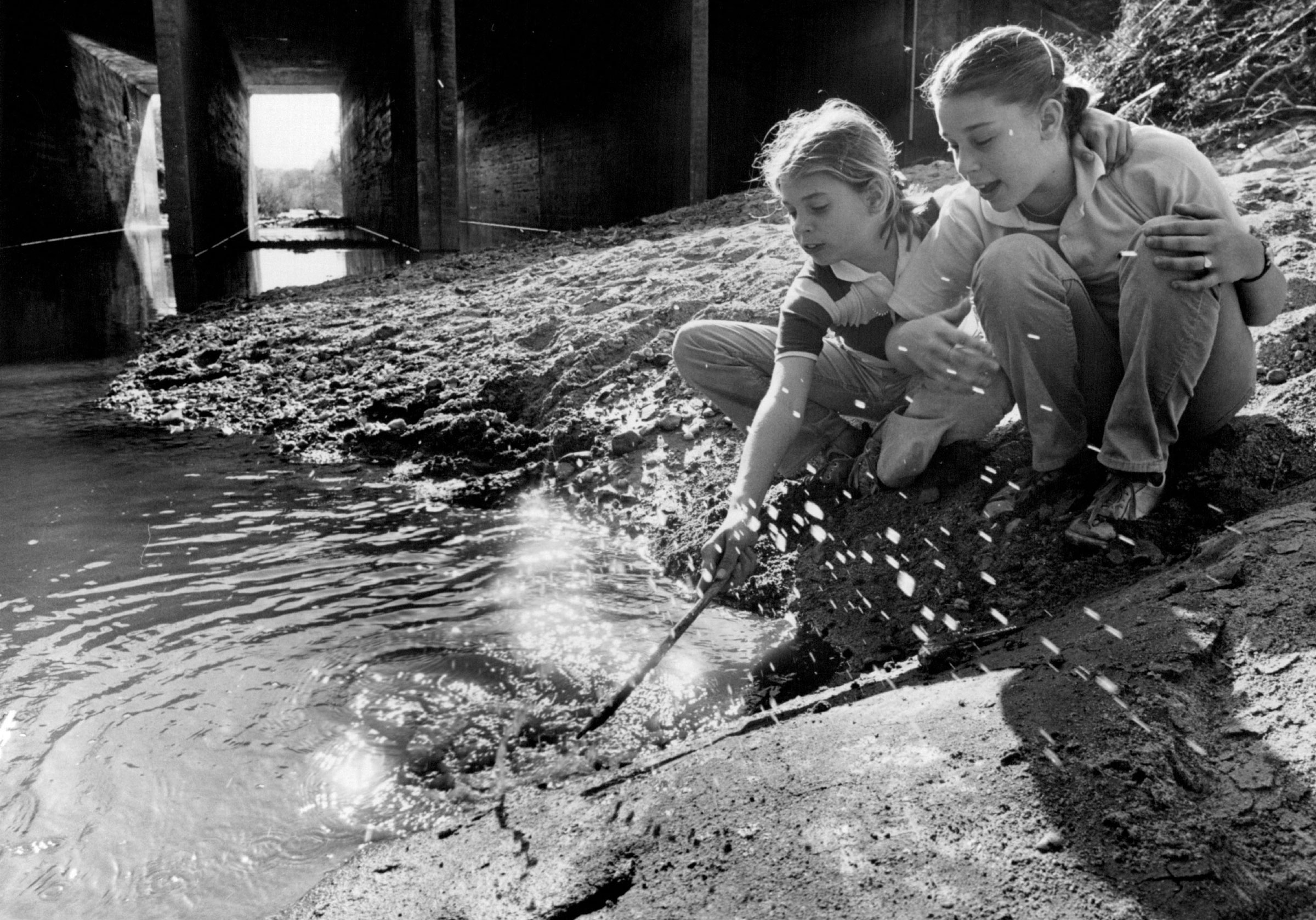 In April 1980, Mary Reynolds and Jennifer Reid, both 11, landed a crayfish from Briar Creek under Providence Road. Photo: Charlotte Observer archives